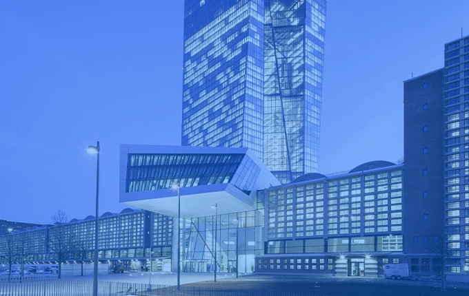 Architecture moderne d'un grand bâtiment de banque avec une tour en verre, teintée en bleu.