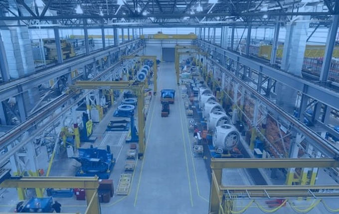 Un grand atelier industriel pour la fabrication de turbines éoliennes, teinté en bleu.